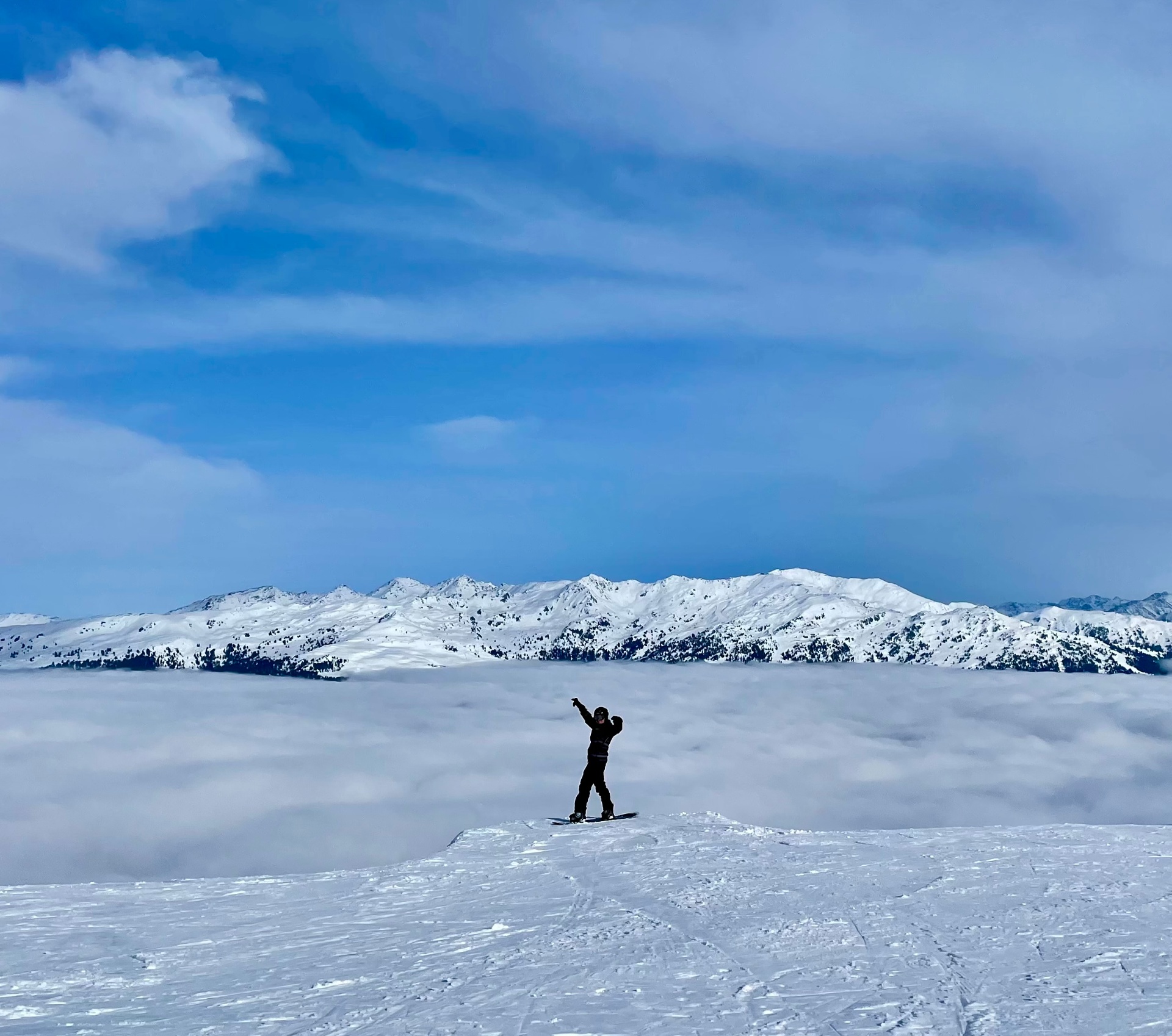 Joris snowboarding on an Alpine ridge above the clouds.